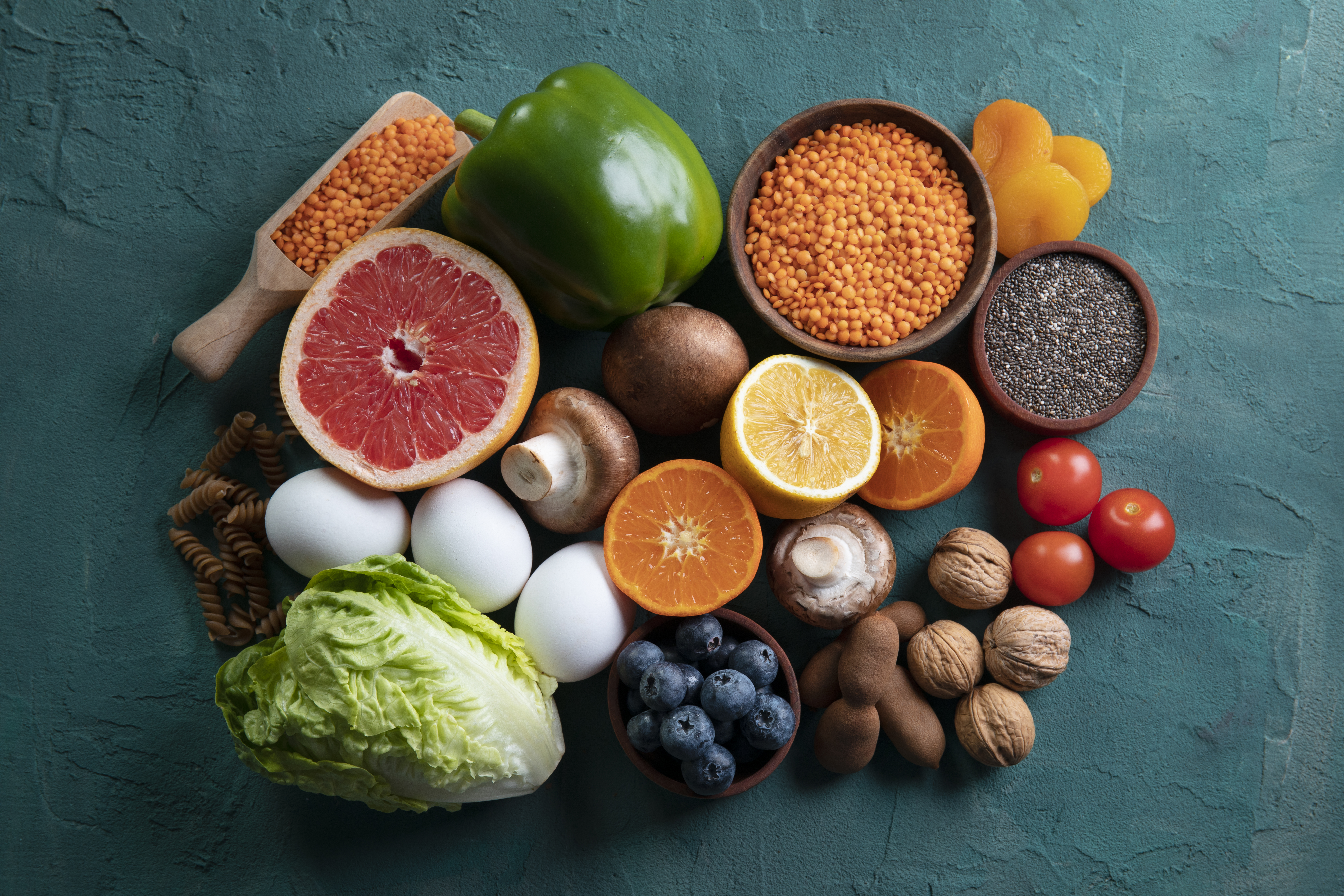 Varied selection of fiber rich foods on a teal background.