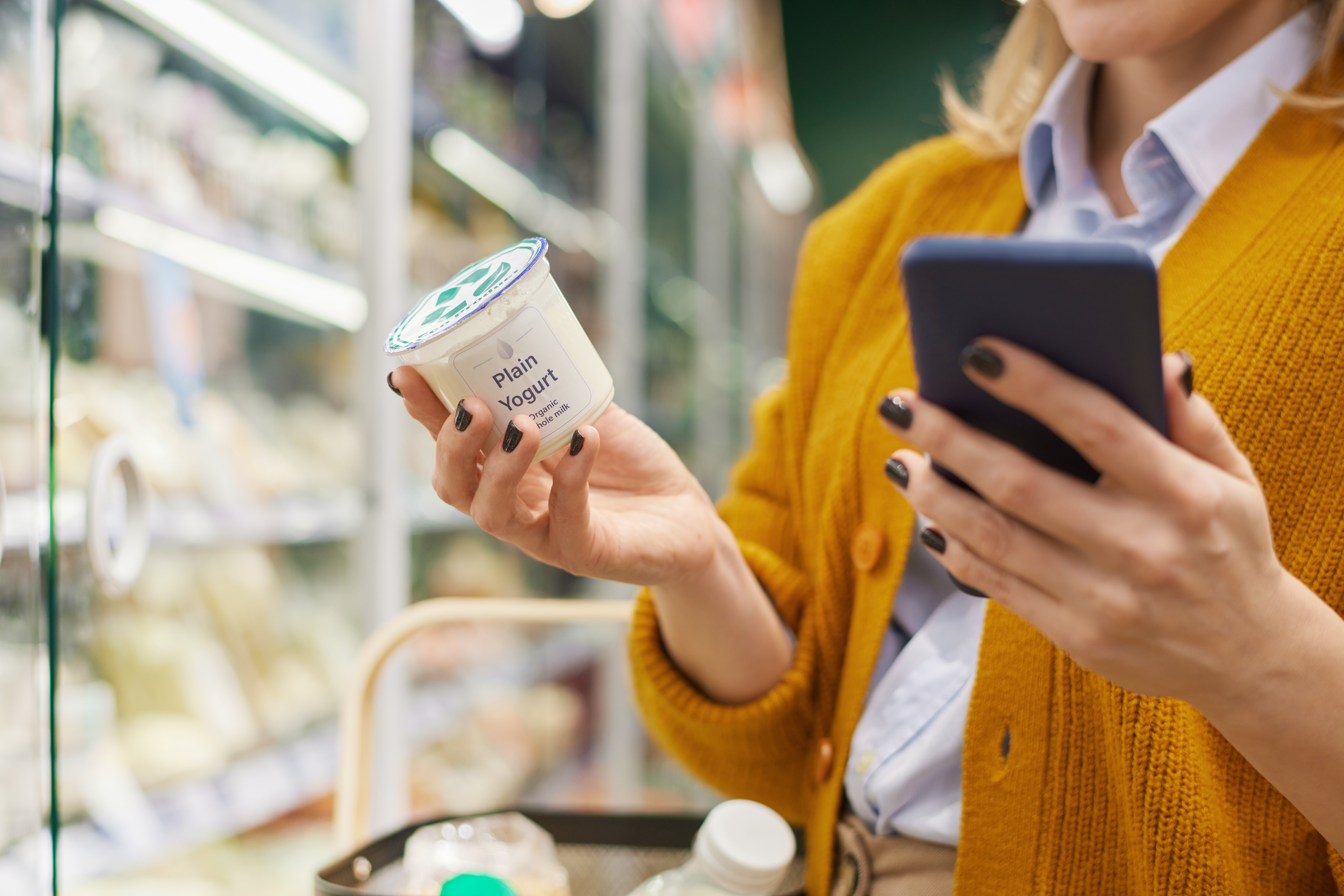 Lady reading the food label on a plain yogurt pot