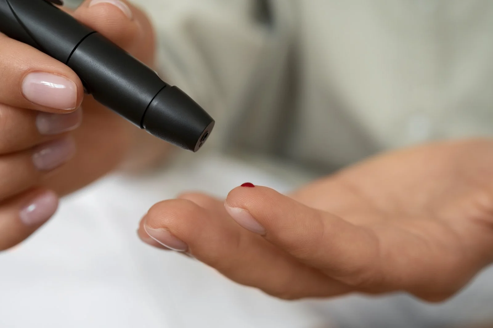 Woman checking her blood glucose level at home